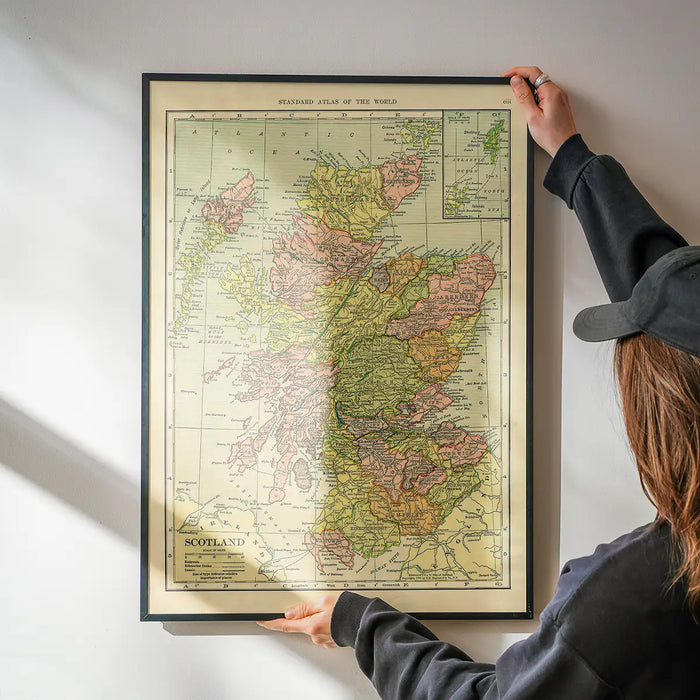 C. S. Hammond map of Scotland being hung on a wall in a black frame