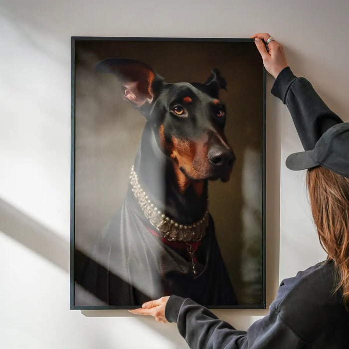 Doberman Dog Portrait Print being hung on a wall in a black frame